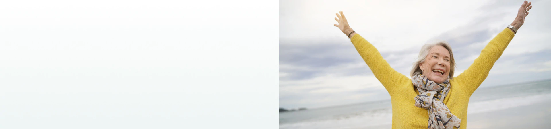A joyful elderly woman raising her arms at the beach, representing the benefits of supplements for energy and vitality.