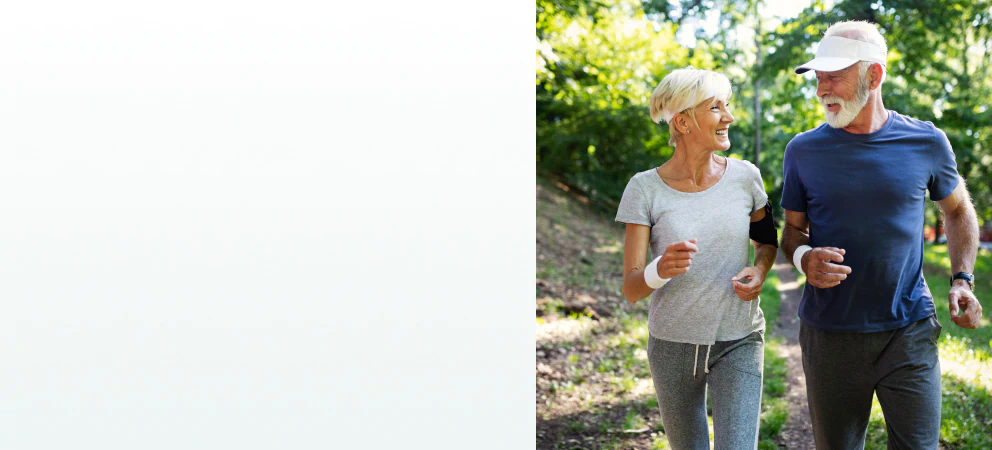 A senior couple jogging outdoors, smiling and enjoying an active lifestyle supported by supplements for optimal health.