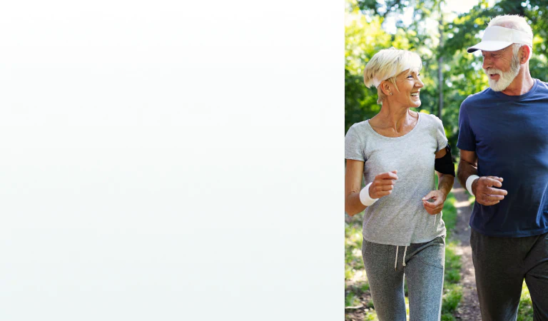A senior couple jogging outdoors, smiling and enjoying an active lifestyle supported by supplements for optimal health.