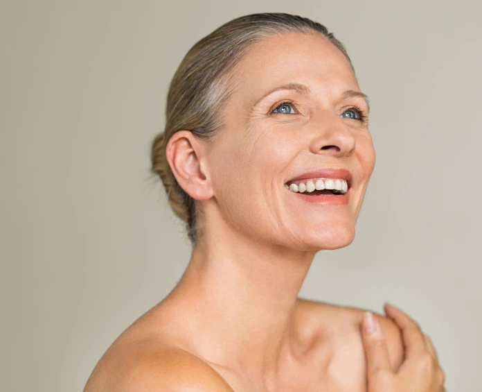 A woman with glowing, youthful skin smiling naturally, representing the best supplements for skin and beauty.