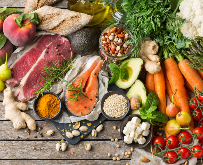 A colorful spread of healthy foods, including lean meats, vegetables, nuts, and grains, supporting weight loss supplements.