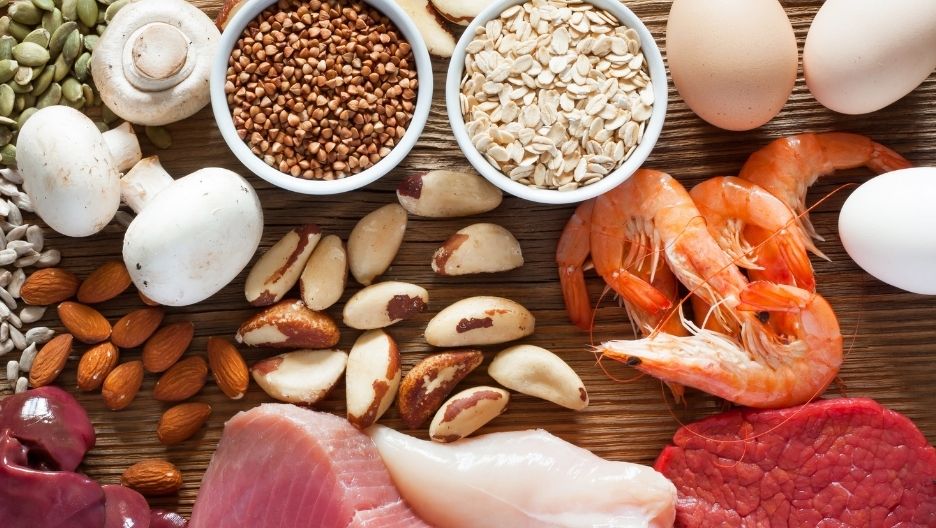 A top-down image displaying a variety of selenium-rich foods, including shrimp, Brazil nuts, mushrooms, eggs, chicken.
