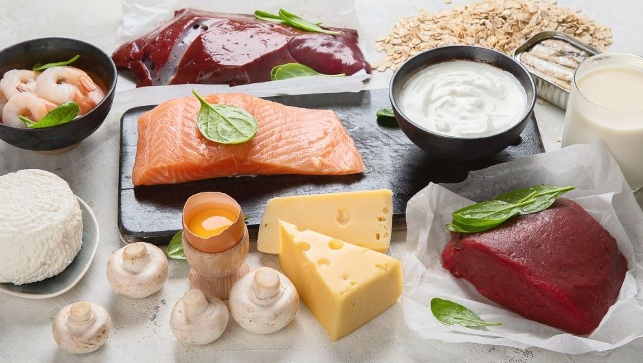A top-down image displaying a variety of Vitamin B12-rich foods, including salmon fillet, liver, beef, cheese.