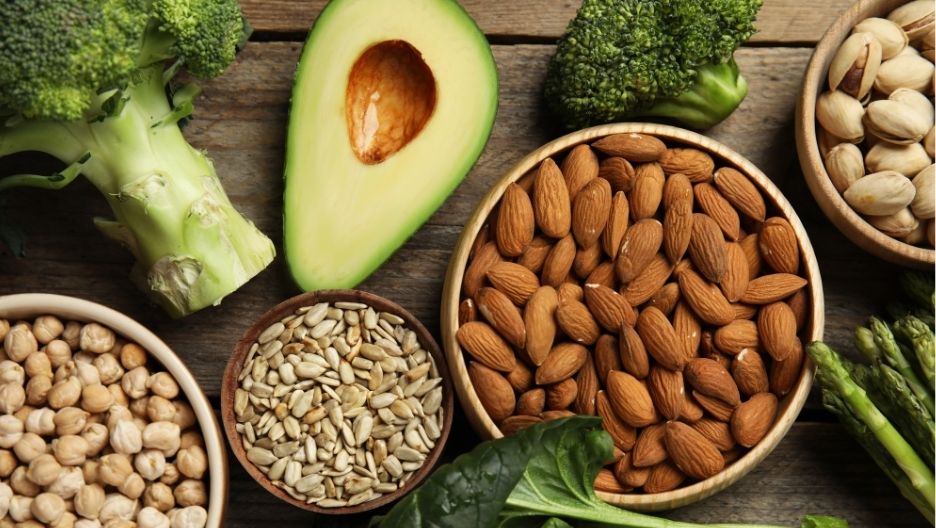 A top-down image displaying a variety of Vitamin E-rich foods, such as almonds, avocado, and broccoli.
