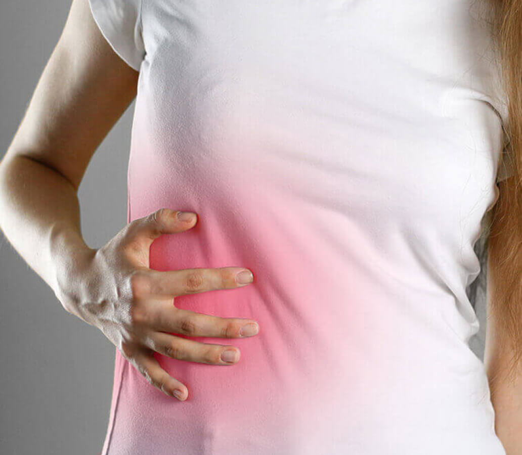 woman touching her side in pain